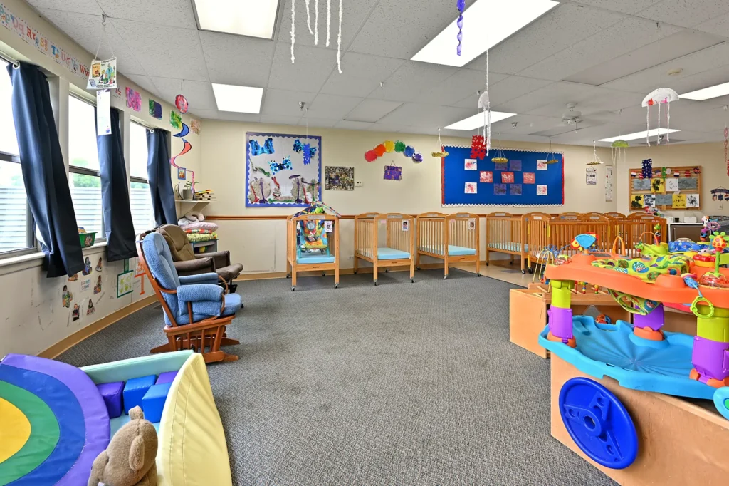 Infant room with cribs and play area in Island Lake